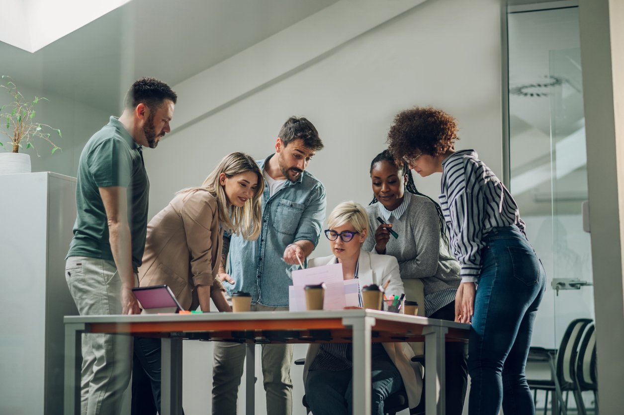 Group of people round a table working together.